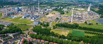 Luchtfoto van een industrieterrein met fabrieken, omgeven door groen.