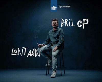 Man op een stoel in een donkere omgeving met teksten erbij.